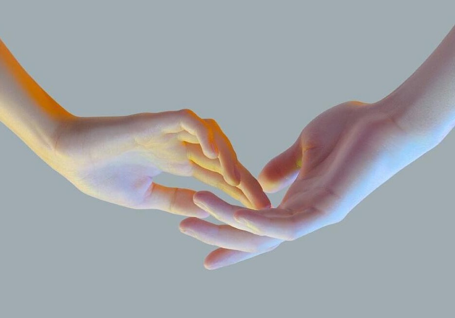 Hands reaching out to each other, almost touching